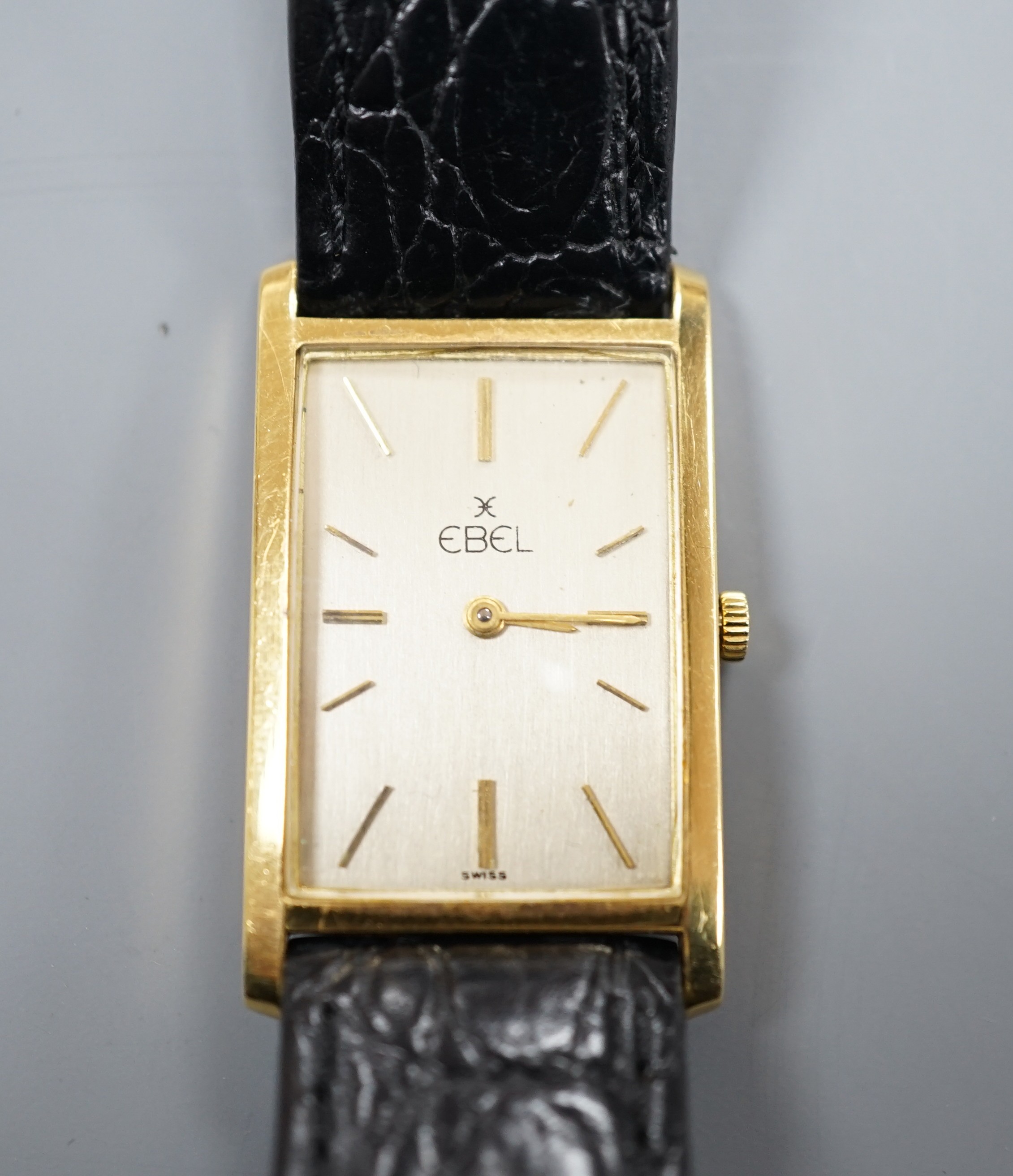A gentleman's 750 yellow metal Ebel rectangular dial manual wind wrist watch, on associated leather strap, case diameter 22mm, gross weight 24.3 grams.
